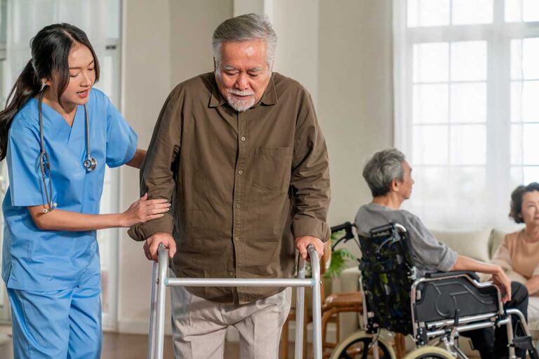A senior resident using a handrail in a well-lit hallway with safety grab bars and slip-resistant flooring.
